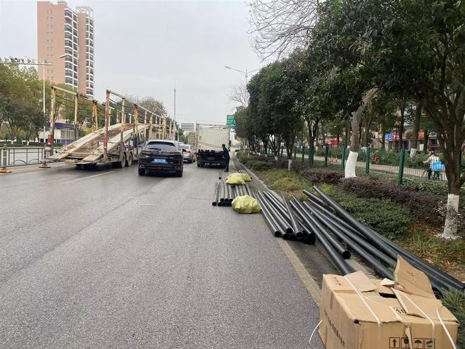 货车过红绿灯时甩下数根PE管蔡甸城管队员客串搬运工10余钟装车清障(图1)