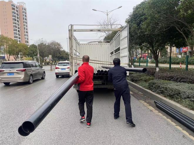 货车过红绿灯时甩下数根PE管蔡甸城管队员客串搬运工10余钟装车清障(图2)